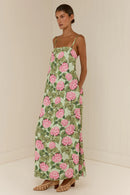 Woman wearing a floral dress with pink flowers on a plain background