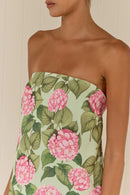 Strapless dress with pink floral and green leaf pattern on a neutral background
