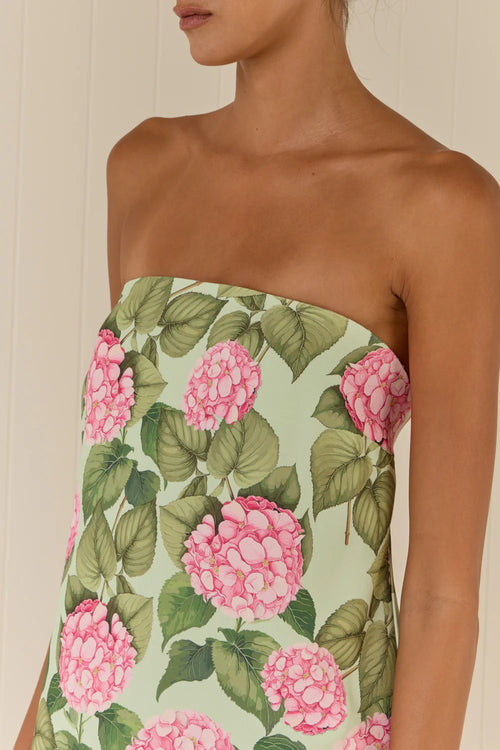 Strapless dress with pink floral and green leaf pattern on a neutral background