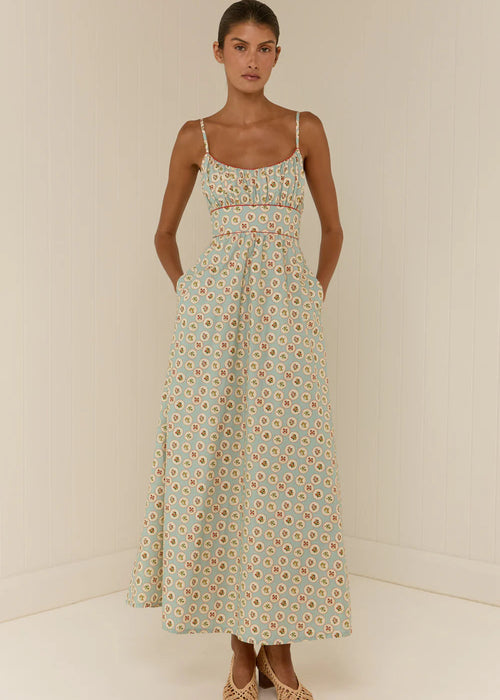 Woman wearing a floral dress against a plain background