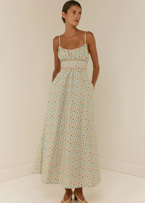 Woman wearing a floral dress against a plain background
