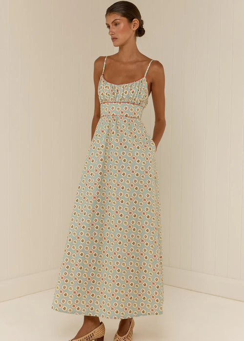 Woman wearing a floral dress against a plain background