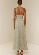 Woman wearing a floral dress with thin straps on a plain background