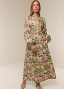 Woman wearing a floral dress with pink flowers on a plain background
