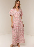 Woman wearing a pink floral dress against a white background