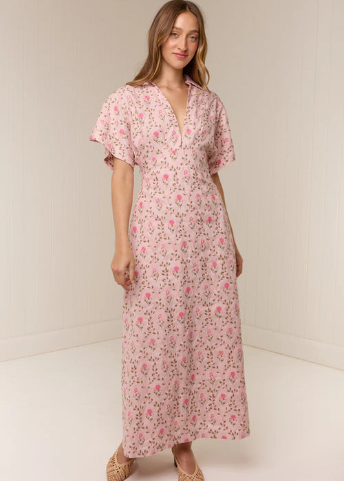 Woman wearing a pink floral dress against a white background