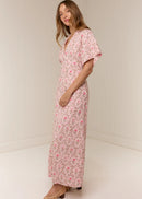 Woman wearing a pink floral dress against a white background