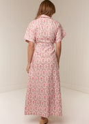 Woman wearing a pink floral dress against a white background