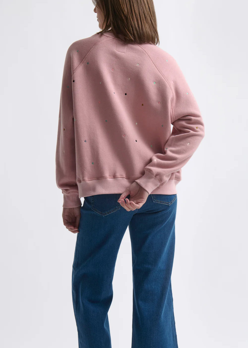 Woman wearing a pink sweatshirt on a white background