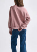 Woman wearing a pink sweatshirt on a white background