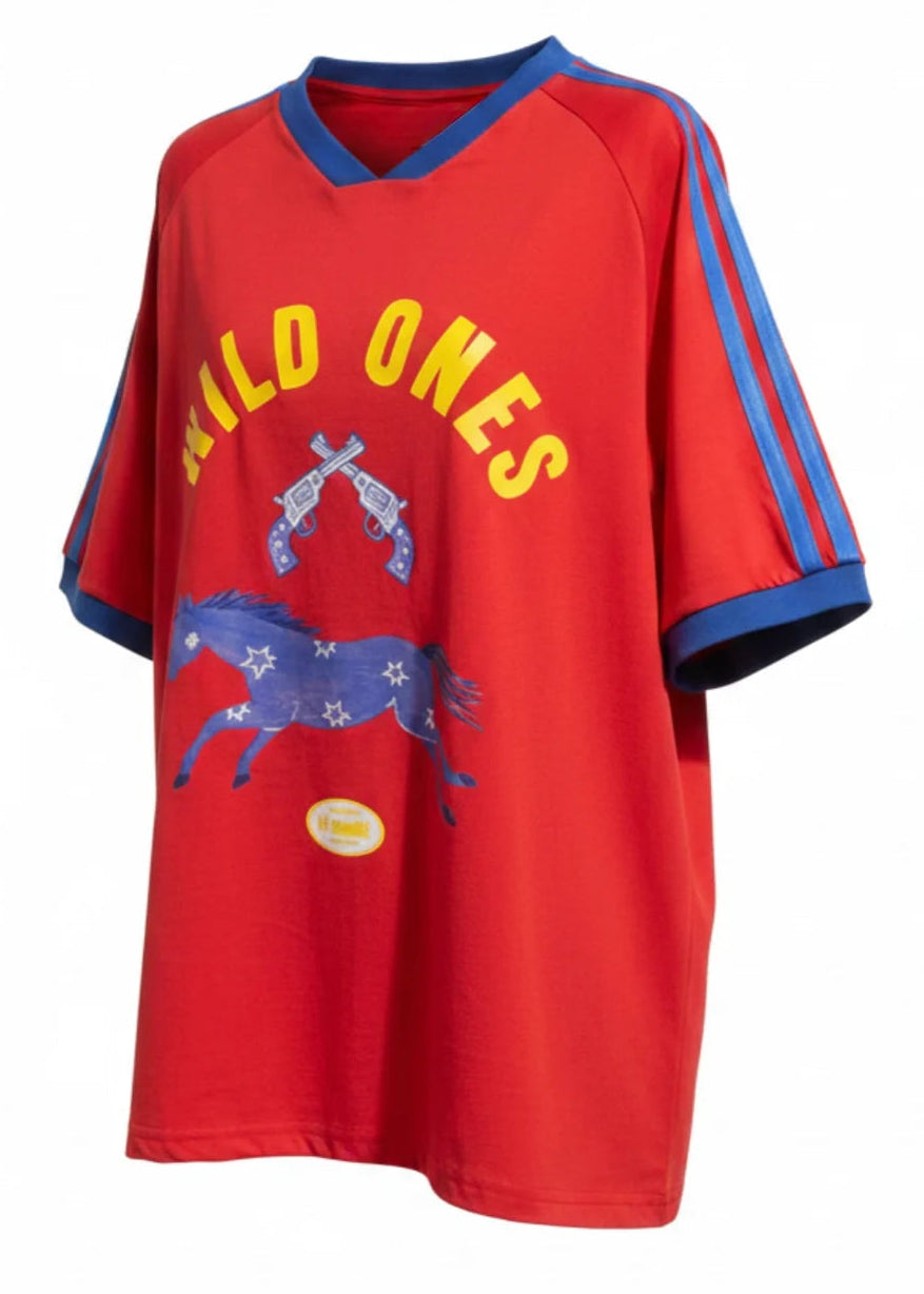 A red short-sleeve V-neck t-shirt with blue trim on the collar and sleeve cuffs, featuring yellow 'WILD ONES' text and a blue horse graphic on the front.