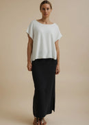 Woman modelling a white top on a beige background