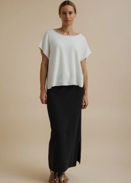 Woman modelling a white top on a beige background