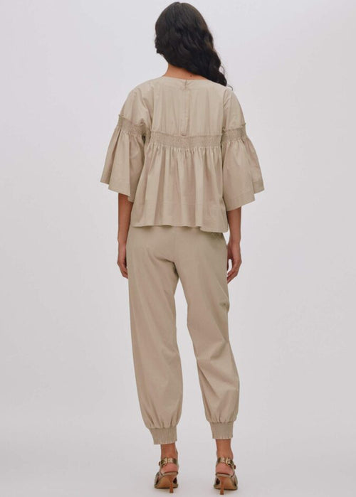 Woman wearing a beige outfit on a white background