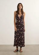 Woman wearing a floral nightgown against a plain background