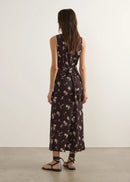Woman wearing a floral nightgown against a plain background