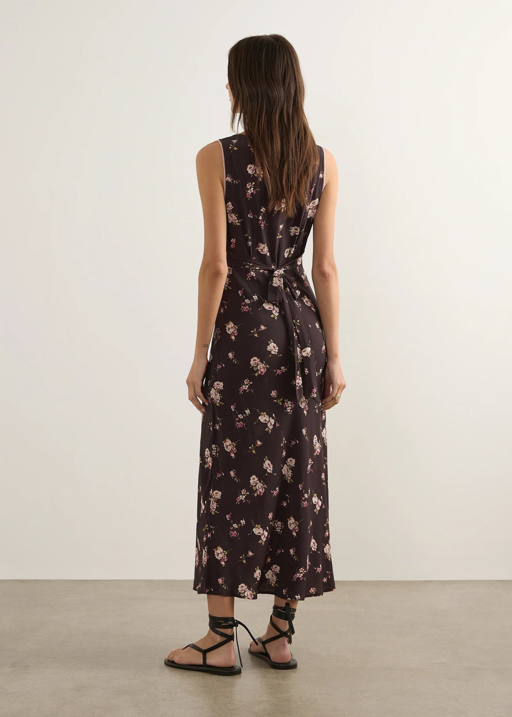 Woman wearing a floral nightgown against a plain background
