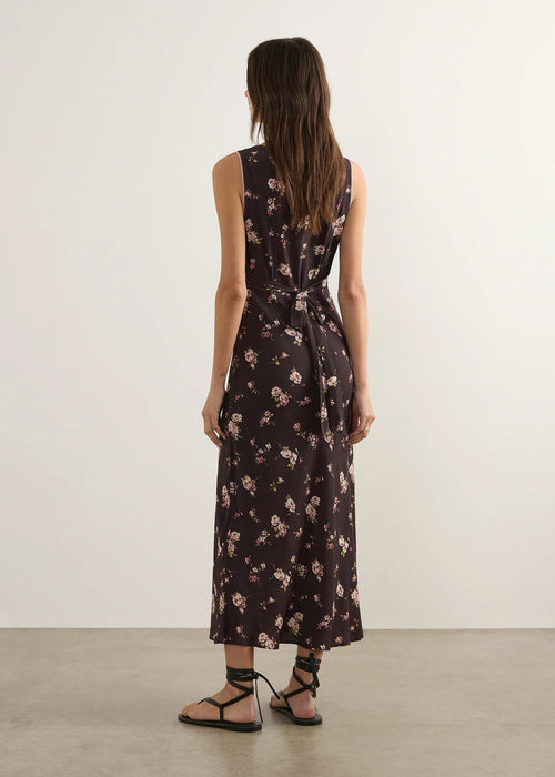 Woman wearing a floral nightgown against a plain background