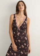 Woman wearing a floral nightgown against a plain background