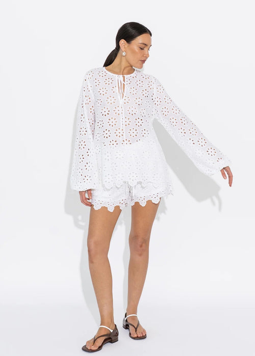 Woman wearing a white lace top on a white background