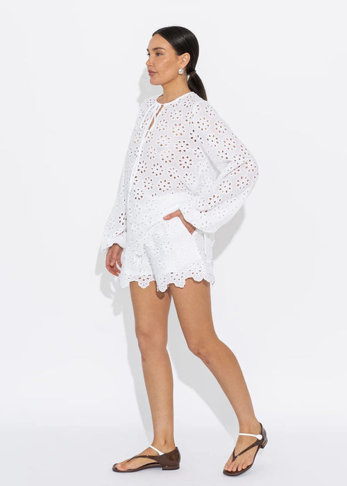 Woman wearing a white lace top on a white background