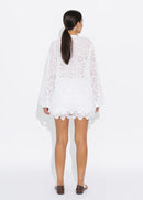 Woman wearing a white lace top on a white background