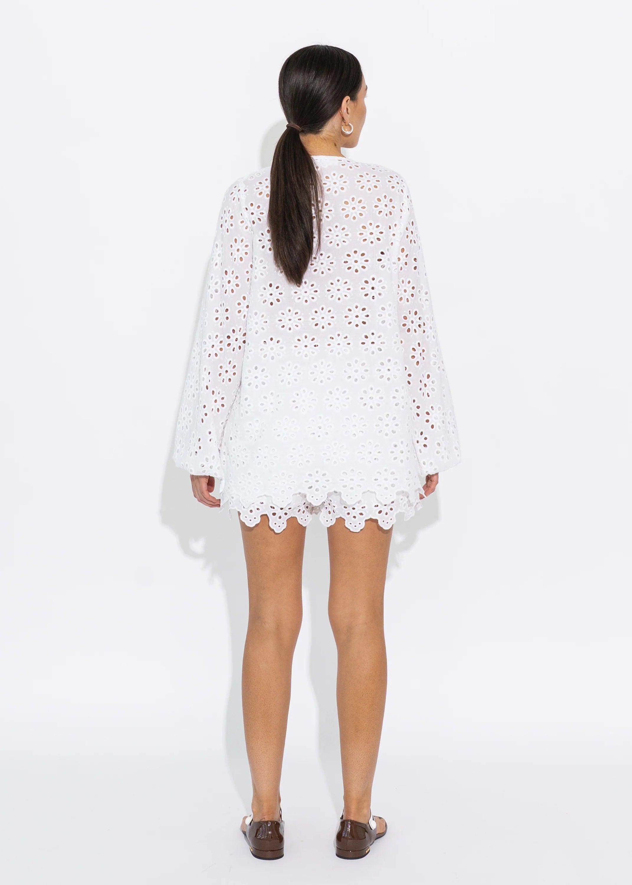 Woman wearing a white lace top on a white background