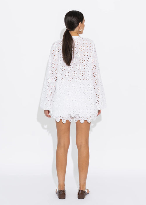 Woman wearing a white lace top on a white background