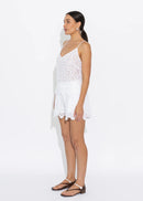 Woman wearing a white lace cami on a white background