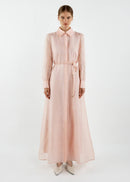 Woman wearing a long light pink dress on a white background