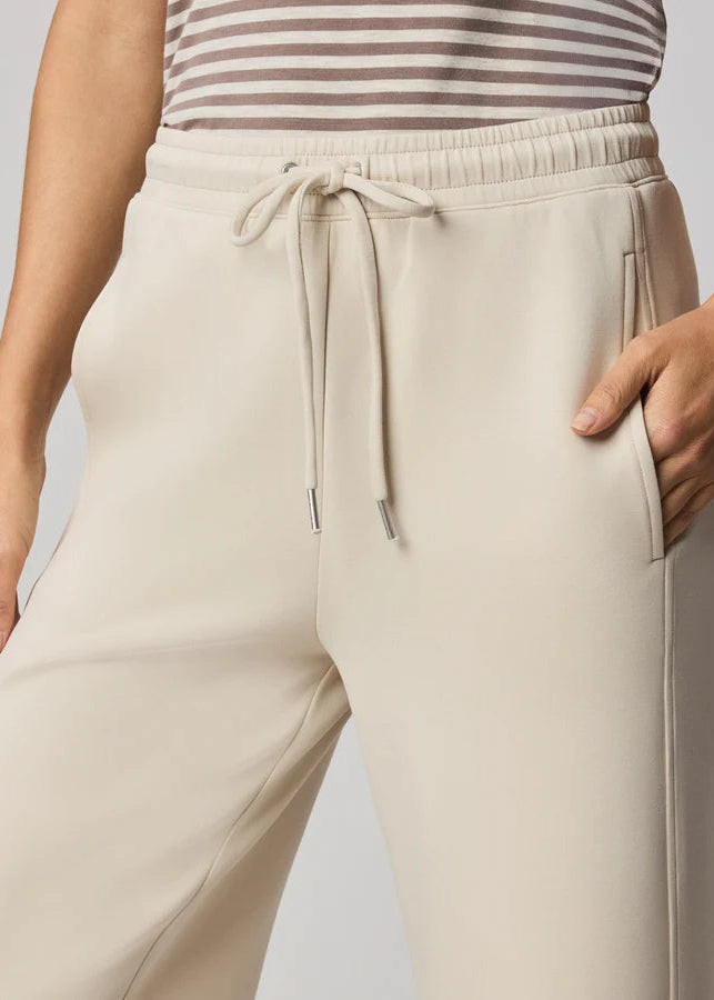 Beige sweatpants worn by a person on a plain background