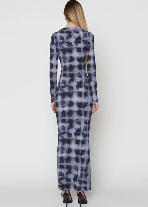 Woman wearing a long-sleeve, patterned dress on a white background