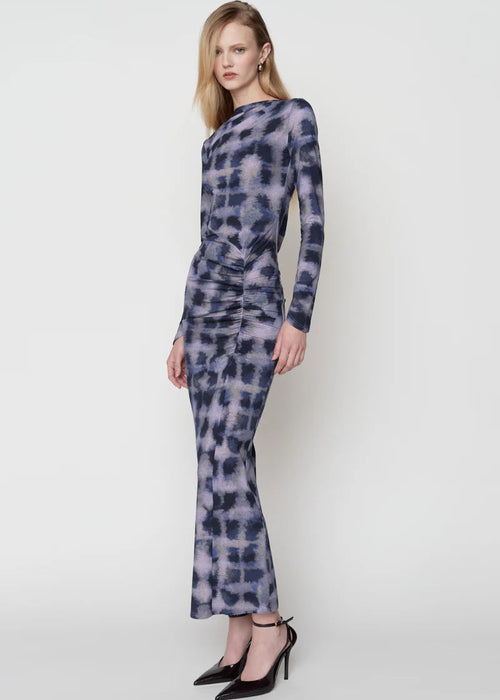 Woman wearing a long-sleeve, patterned dress on a white background