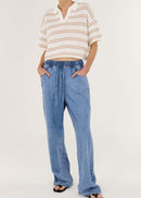 Person wearing a striped shirt and blue jeans on a white background