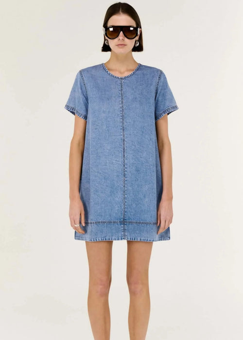 Woman wearing a blue denim dress on a white background