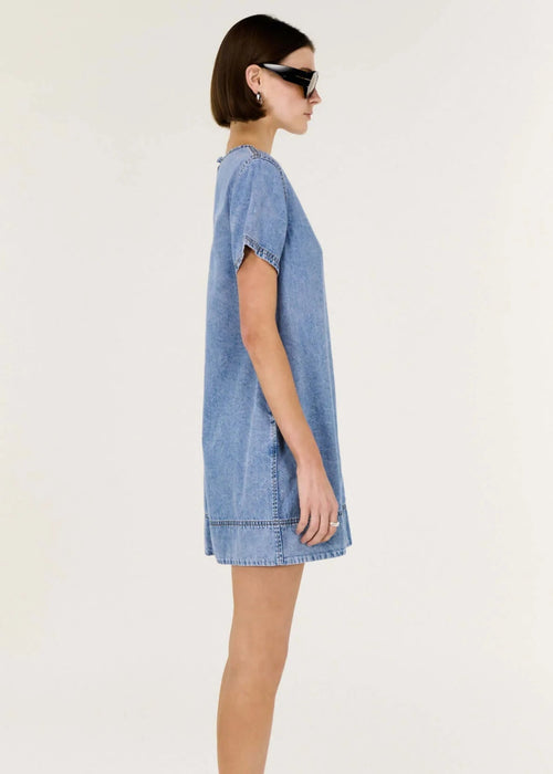 Woman wearing a blue denim dress on a white background