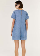 Woman wearing a blue denim dress on a white background