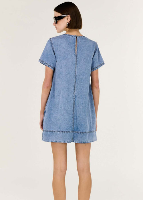 Woman wearing a blue denim dress on a white background