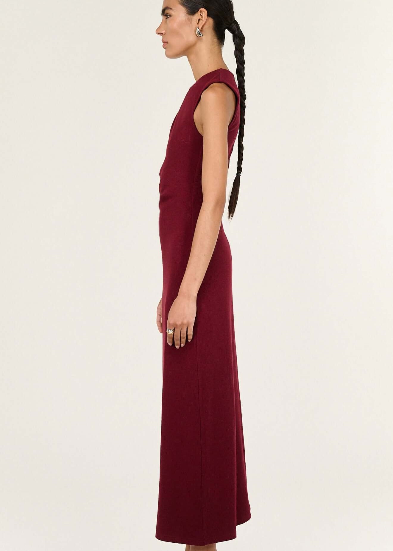 Woman wearing a burgundy sleeveless dress on a white background