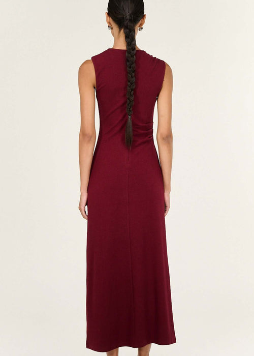 Woman wearing a burgundy dress with a white background