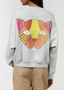 Gray sweatshirt with a colourful cat face design on the back, worn by a person.