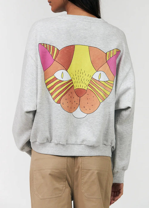 Gray sweatshirt with a colourful cat face design on the back, worn by a person.