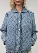 Person wearing a blue quilted jacket with a white background
