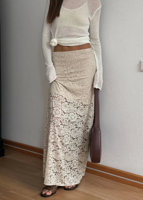 Woman in a white top and lace skirt  with a white background