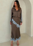 Woman wearing a brown outfit with lace details in a neutral setting