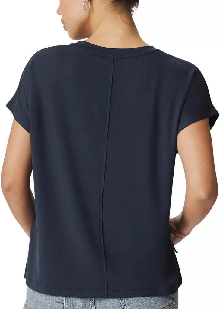 A woman shown from the back wearing a dark navy blue short-sleeve top and light blue jeans against a plain white background.