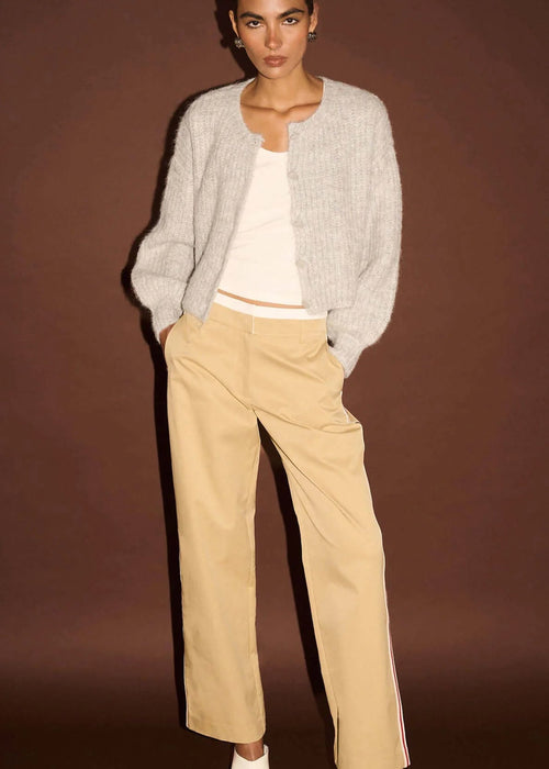 Woman white top, beige pants, on a brown background
