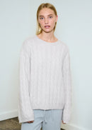 Woman wearing white jumper on white background