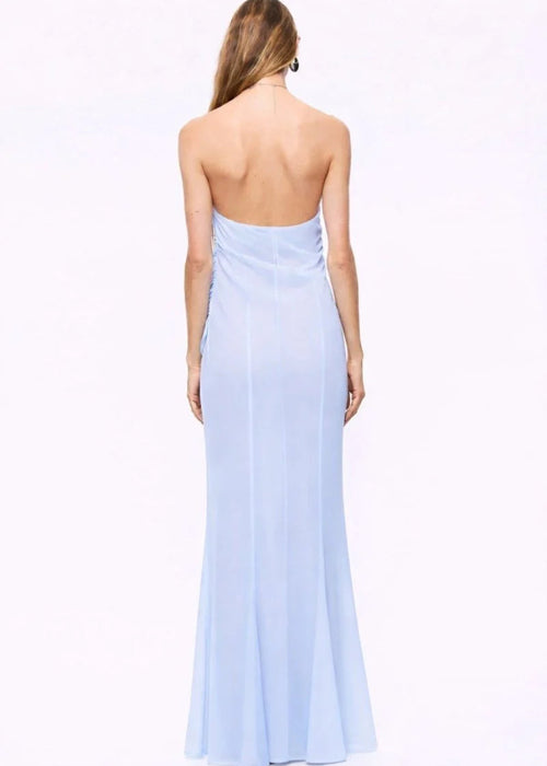Woman wearing a light blue halter neck gown on a white background