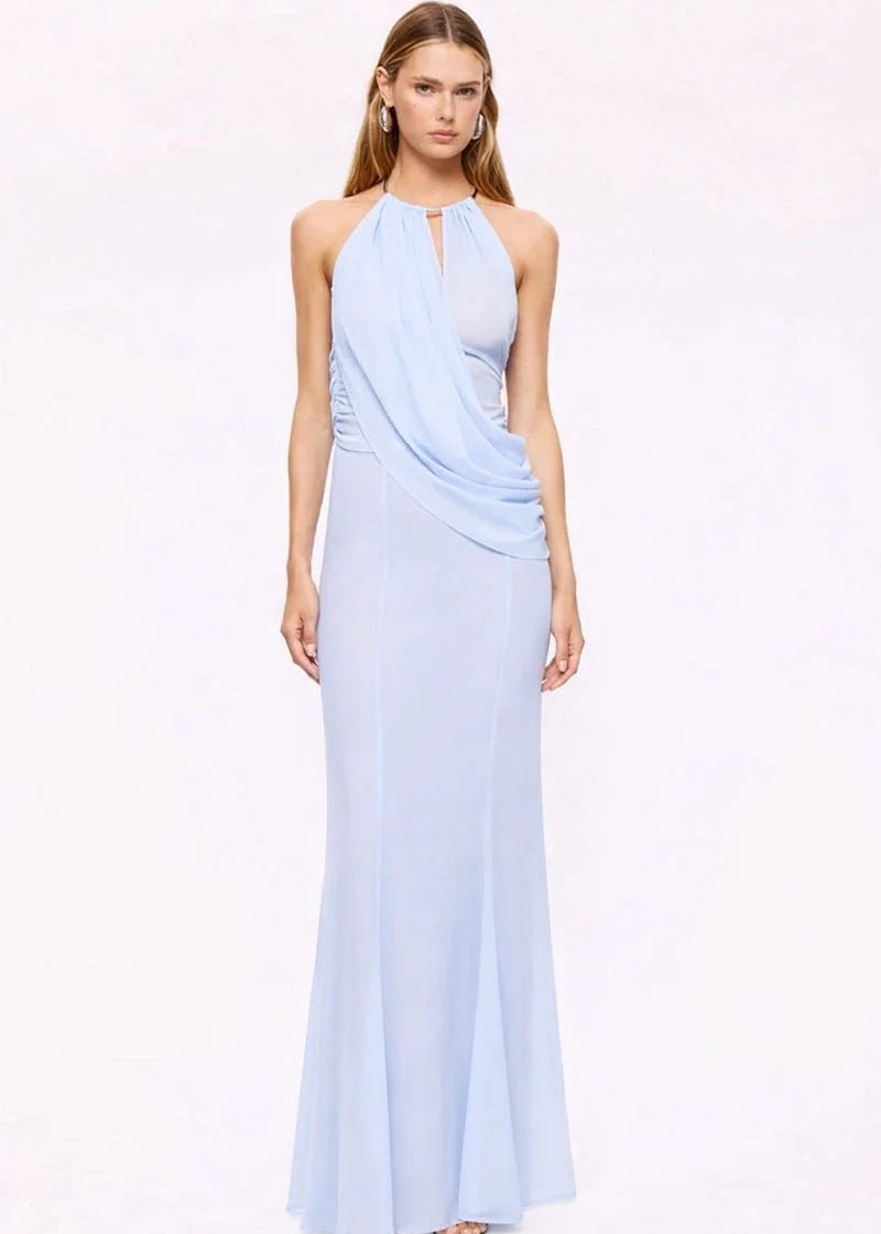 Woman wearing a light blue halter neck gown on a white background